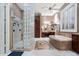 Spacious bathroom boasting a glass-enclosed shower, soaking tub, dual vanities and detailed tile work at 41711 N Pinion Hills Ct, Anthem, AZ 85086