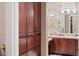 Bathroom featuring cherry wood cabinets and dual sinks with view into the shower at 41711 N Pinion Hills Ct, Anthem, AZ 85086