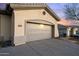 View of garage and desert sunset sky at 41711 N Pinion Hills Ct, Anthem, AZ 85086