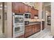 Modern kitchen with stainless steel appliances and beautiful dark wood cabinetry at 41711 N Pinion Hills Ct, Anthem, AZ 85086