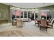 Open-concept living room with a dining table and a wall of windows with sunset views at 41711 N Pinion Hills Ct, Anthem, AZ 85086