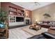 Living room featuring custom built-ins, fireplace, and cozy leather furniture at 41711 N Pinion Hills Ct, Anthem, AZ 85086