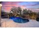 Twilight shot of a backyard pool with waterfall and desert landscaping at 41711 N Pinion Hills Ct, Anthem, AZ 85086