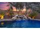 Backyard pool waterfall feature surrounded by desert landscaping at sunset at 41711 N Pinion Hills Ct, Anthem, AZ 85086