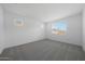 A clean bedroom featuring carpeted floors and a large window providing ample natural light at 4238 W Brenley Dr, San Tan Valley, AZ 85144