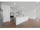 Open-concept kitchen with an island, gray cabinets, stainless steel appliances, and wood-look tile flooring at 4238 W Brenley Dr, San Tan Valley, AZ 85144