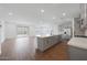 Spacious open-concept kitchen and living area with stainless steel appliances and wood-look tile floors at 4238 W Brenley Dr, San Tan Valley, AZ 85144
