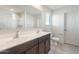 Bathroom with dual vanity sinks, granite countertops, and modern fixtures at 42860 W Peters Dr, Maricopa, AZ 85138