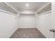 Walk-in closet with carpet and ample storage with bars for hanging clothing at 42860 W Peters Dr, Maricopa, AZ 85138