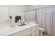 Well-lit bathroom with a double sink vanity, a large mirror, and a shower with a patterned curtain at 4936 E Villa Rita Dr, Scottsdale, AZ 85254