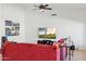 Comfortable living room featuring a ceiling fan and a large, inviting red couch at 4936 E Villa Rita Dr, Scottsdale, AZ 85254