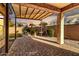 An outdoor backyard with a covered patio area, rock features, and mature landscaping at 5265 S Dante --, Mesa, AZ 85212