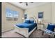 A well lit bedroom with a queen size bed, neutral color scheme, and a large window at 5334 S Parkwood --, Mesa, AZ 85212