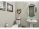 Cozy powder room with a pedestal sink, toilet, and decorative wall art at 5334 S Parkwood --, Mesa, AZ 85212