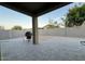 Spacious, low-maintenance backyard with a large brick wall and a covered patio area at 559 W Magena Dr, San Tan Valley, AZ 85140