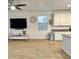 Open-concept space with modern flooring, ceiling fan, mounted television, and adjacent kitchen at 559 W Magena Dr, San Tan Valley, AZ 85140