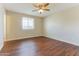 Relaxing bedroom with hardwood floors, a ceiling fan, and a bright window offering natural light at 707 N 92Nd Pl, Mesa, AZ 85207