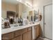 Bathroom featuring dual sinks, vanity, large mirror, and modern lighting at 7808 W Palo Verde Dr, Glendale, AZ 85303