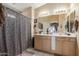 Bathroom with dual sinks, vanity, and shower with unique curtain at 7808 W Palo Verde Dr, Glendale, AZ 85303