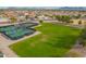 Aerial showcases well-maintained pickleball courts, a lush lawn, and mature trees at 8118 E Medina Ave, Mesa, AZ 85209