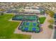 Aerial view of the pickleball courts with players, surrounded by lush lawns and community buildings at 8118 E Medina Ave, Mesa, AZ 85209