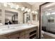 Primary bathroom with double vanity, wood cabinets, and a glass door shower at 8118 E Medina Ave, Mesa, AZ 85209
