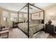 Cozy bedroom features a four-poster bed, ceiling fan, and large windows overlooking the lawn at 8118 E Medina Ave, Mesa, AZ 85209