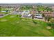 Wide aerial view of the lush golf course surrounded by green trees, nearby clubhouse, and residential community beyond at 8118 E Medina Ave, Mesa, AZ 85209