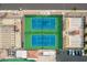 Aerial view of tennis courts with shade structures, seating, and nearby parking in a planned community at 8118 E Medina Ave, Mesa, AZ 85209