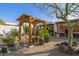 Lush backyard featuring a dining pergola, desert landscaping, and outdoor seating; perfect for relaxing at 8720 E Via De Dorado --, Scottsdale, AZ 85258