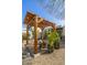 Picturesque backyard with wooden pergola, potted plants, and desert landscaping at 8720 E Via De Dorado --, Scottsdale, AZ 85258