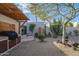 Serene backyard featuring mature trees, desert landscaping, a built-in grill, and a calming Buddha statue at 8720 E Via De Dorado --, Scottsdale, AZ 85258