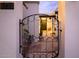 Inviting front entrance featuring a decorative metal gate, desert landscaping, and well-lit pathway at 8720 E Via De Dorado --, Scottsdale, AZ 85258