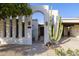 Stunning arched gate with a private entrance to the home, complemented by desert landscaping and unique lighting fixtures at 8720 E Via De Dorado --, Scottsdale, AZ 85258