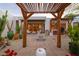 Beautifully designed outdoor patio area with pergola, fire pit, grill, and lush plantings at 8720 E Via De Dorado --, Scottsdale, AZ 85258