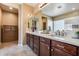 Bathroom features double sinks, wood cabinets, and tiled walk-in shower with glass block window at 9952 W Jessie Ln, Peoria, AZ 85383