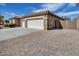 A large garage with stone detailing, a tile roof, and a spacious driveway creates an inviting exterior elevation at 9952 W Jessie Ln, Peoria, AZ 85383