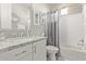 Bathroom with white vanity, granite countertops, and shower/tub with gray curtain at 10054 E Bell Rd, Scottsdale, AZ 85260