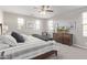 Well-lit bedroom featuring a ceiling fan, dresser with TV, and a comfortable seating area at 10054 E Bell Rd, Scottsdale, AZ 85260