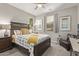 Well-lit bedroom with a ceiling fan, bedside table, and window with natural light at 10054 E Bell Rd, Scottsdale, AZ 85260