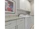 Well-lit laundry room featuring a white counter, white cabinets, and a washer and dryer at 10054 E Bell Rd, Scottsdale, AZ 85260