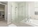 Glass-enclosed shower with tiled walls, a rainfall showerhead, and an adjacent bathtub at 10054 E Bell Rd, Scottsdale, AZ 85260