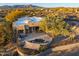 Aerial view of a desert home featuring a patio with a spa and outdoor seating surrounded by desert vegetation at 10767 E Santa Fe Trl, Scottsdale, AZ 85262