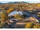 Aerial view of desert home with lush desert landscape and mountain views at 10767 E Santa Fe Trl, Scottsdale, AZ 85262