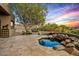 Relaxing backyard spa with rock features, a fire pit, built-in seating, and desert views at 10767 E Santa Fe Trl, Scottsdale, AZ 85262