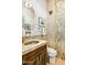 Powder room features designer sink, stone tile accents, and framed artwork at 10767 E Santa Fe Trl, Scottsdale, AZ 85262