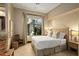 Well-lit bedroom with neutral colors, ceiling fan, and large window with curtain and outdoor views at 10767 E Santa Fe Trl, Scottsdale, AZ 85262