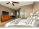 Calm bedroom with lots of sunlight, neutral colors, and ceiling fan. The desk and dresser are wood at 10767 E Santa Fe Trl, Scottsdale, AZ 85262