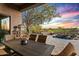 Covered patio with travertine flooring, an outdoor table, and a view of the backyard spa at 10767 E Santa Fe Trl, Scottsdale, AZ 85262