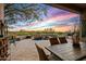 Covered patio with an outdoor kitchen, dining area, and a spa with a rock waterfall feature at 10767 E Santa Fe Trl, Scottsdale, AZ 85262